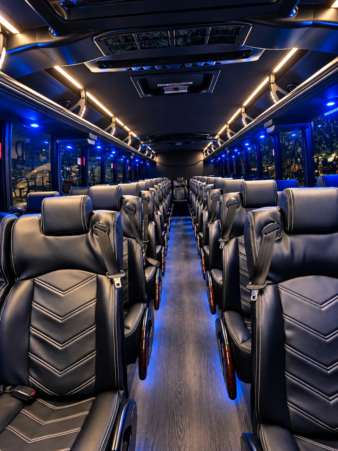 Executive shuttle bus leather-seat interior Forward-facing black leather seats and blue cabin lighting inside an executive shuttle bus