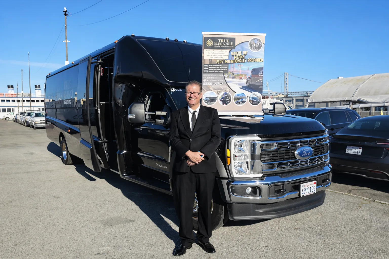 True Elegance chauffeur beside a shuttle bus staged for a Pleasanton conference shuttle program